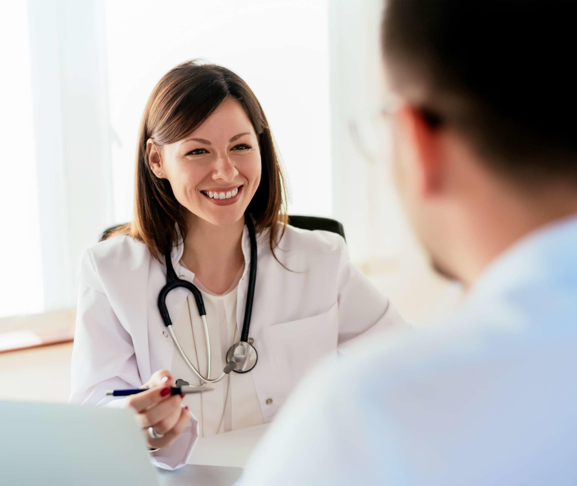 Eine Ärztin lächelt ihren Patienten an