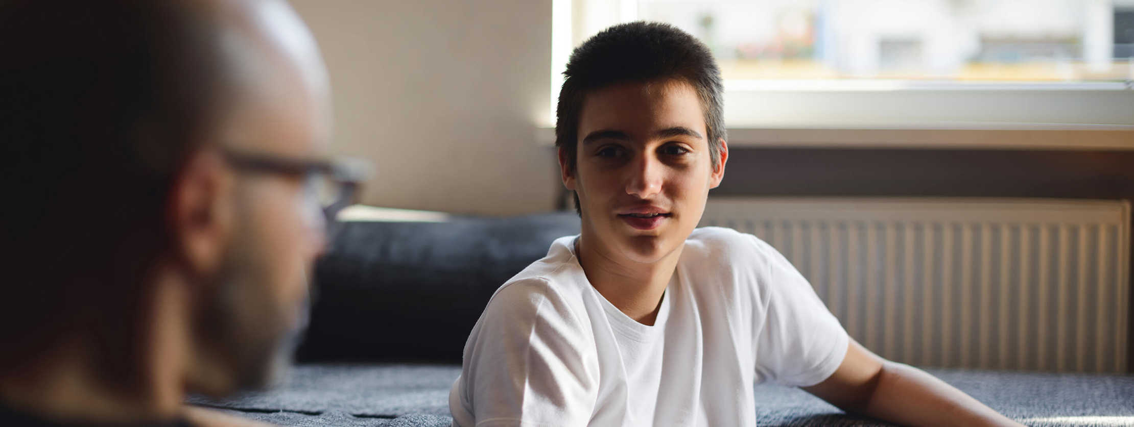 Vater redet mit seinem Sohn im Teenageralter