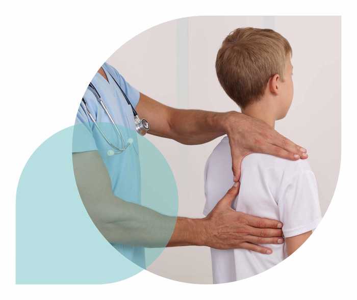 Ratgeber Rheuma: Ein Mediziner untersucht die Schulter eines Jungen