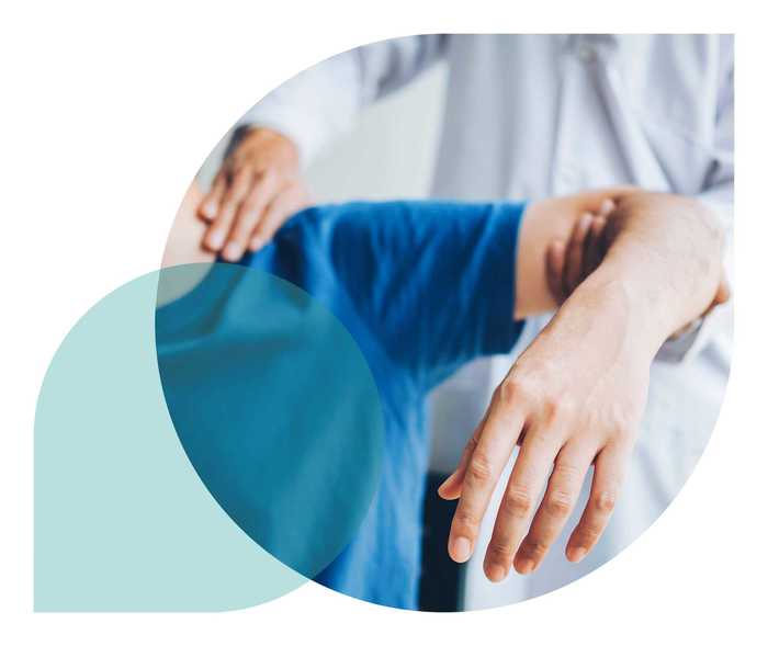 Ratgeber Rheuma: Ein Mediziner behandelt die Schulter eines Rheuma-Patienten