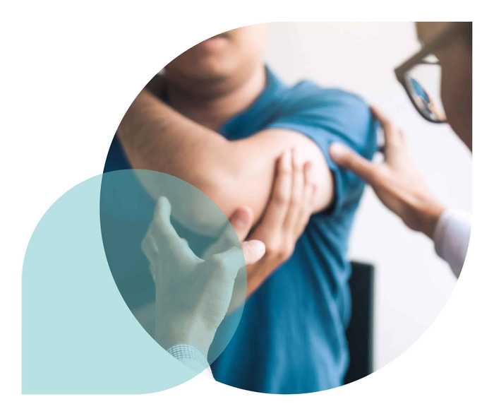 Ratgeber Rheuma: Ein Arzt untersucht das Ellbogengelenk eines Patienten