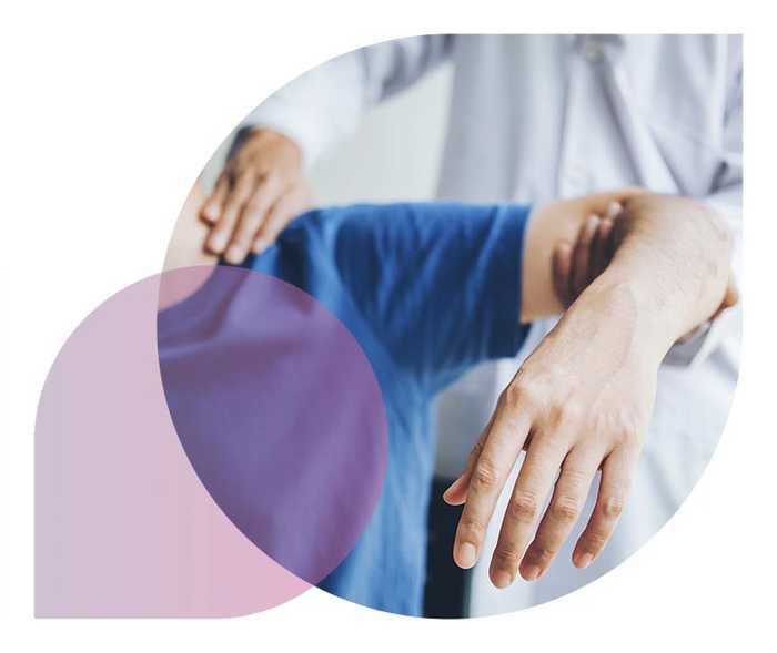 Ratgeber Rheuma: Ein Mediziner behandelt die Schulter eines Rheuma-Patienten