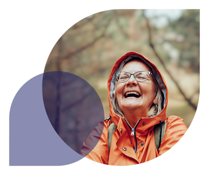 Ratgeber Rheuma: Eine ältere Dame im Regenmantel freut sich