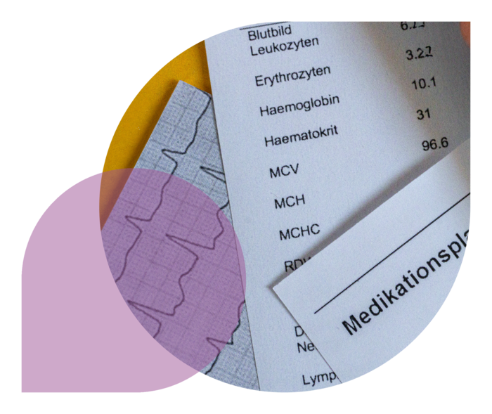 Auf einer gelben Unterlage liegen ausgedruckte Laborwerte und ein Medikationsplan.