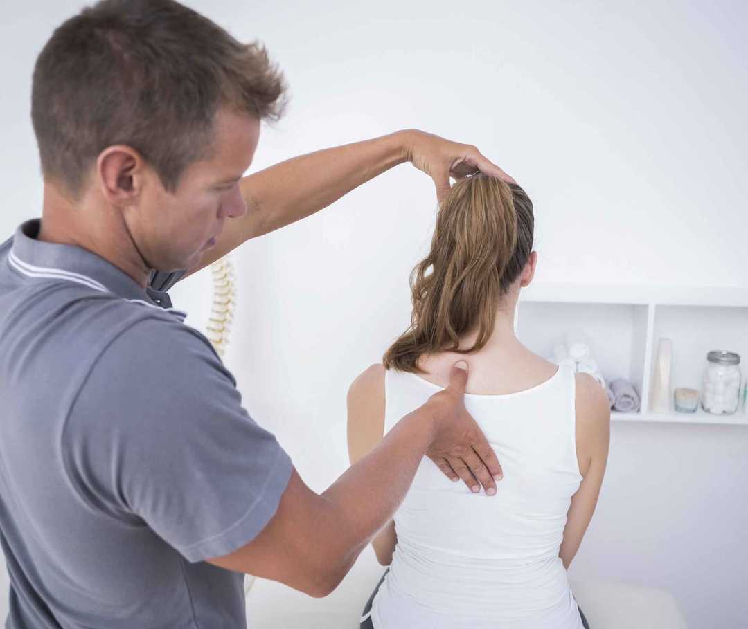 Ratgeber Rheuma: Ein Rheumatologe untersucht die Wirbelsäule einer an Morbus Bechterew Erkrankten