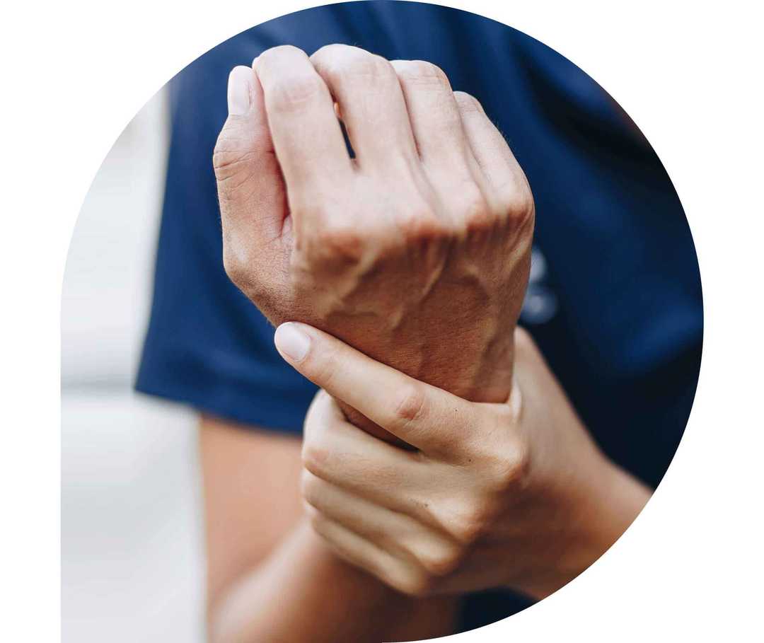 Ratgeber Rheuma: Ein Mann stützt mit der linken Hand sein rechtes schmerzendes Handgelenk Ratgeber Rheuma: Ein Mann stützt mit der linken Hand sein rechtes schmerzendes Handgelenk