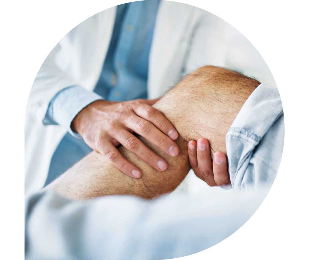Ratgeber Rheuma: Ein Physiotheraupeut behandelt ein Knie eines Patienten