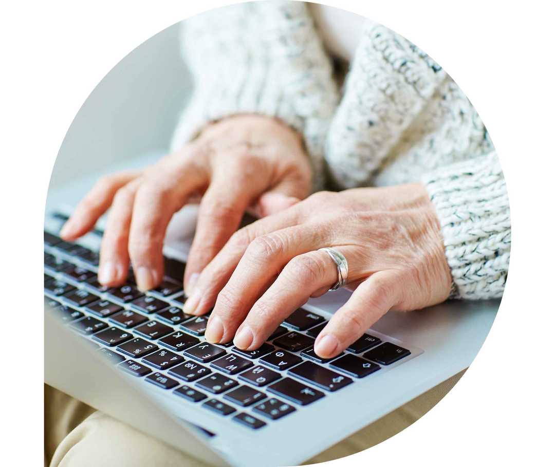 Ratgeber Rheuma: Eine Frau tippt auf der Tastatur eines Notebooks