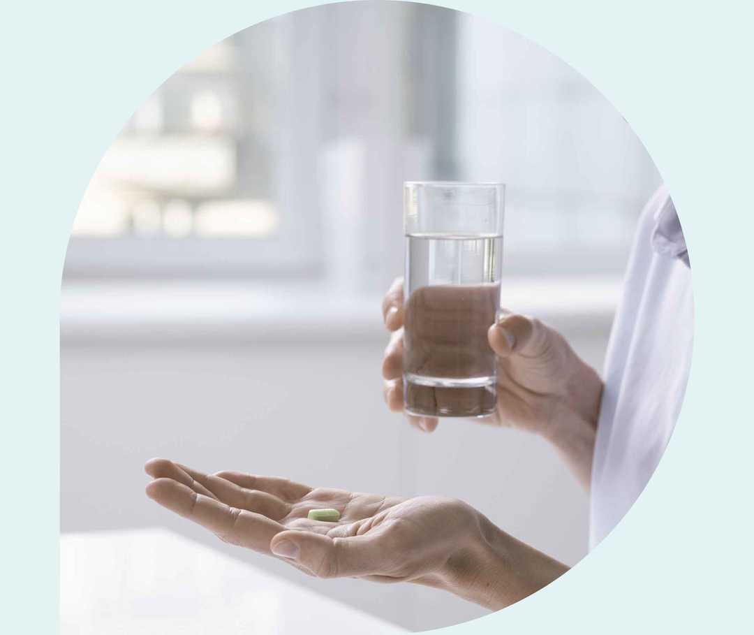 Ratgeber Rheuma: Eine Frau hält in der einen Hand eine Tablette, in der anderen hand ein Wasserglas Ratgeber Rheuma: Eine Frau hält in der einen Hand eine Tablette, in der anderen hand ein Wasserglas