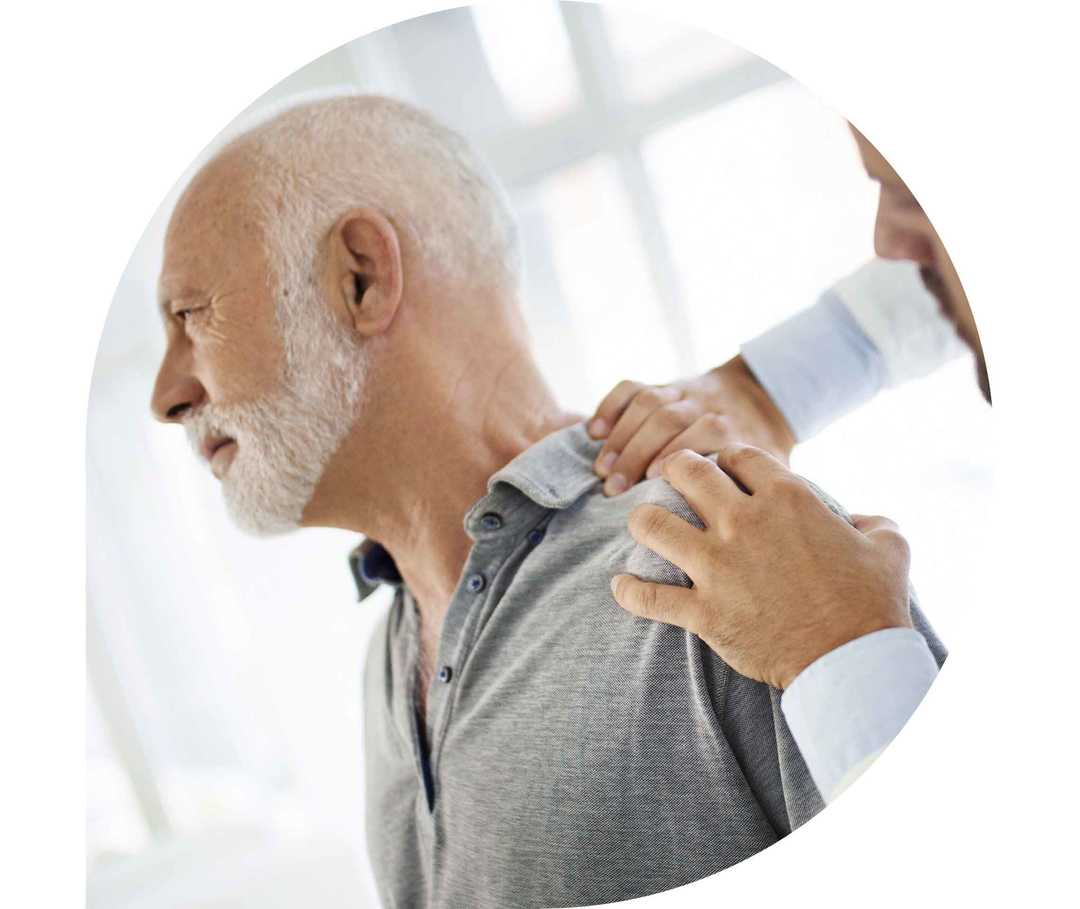 Ratgeber Rheuma: Ein Arzt tastet die rechte Schulter eines Patienten ab