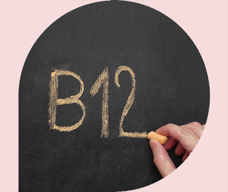 Ratgeber Rheuma: Eine Hand schreibt „B12“ auf eine Tafel