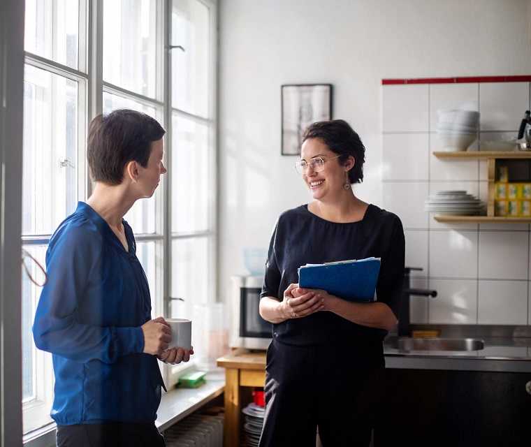 Morbus-Bechterew Patientin Anne und ihre Chefin Frauke unterhalten sich in ihrer Kaffepause