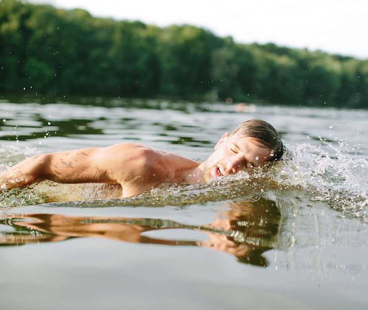 Mann beim Brustschwimmen in einem See Mann beim Brustschwimmen in einem See