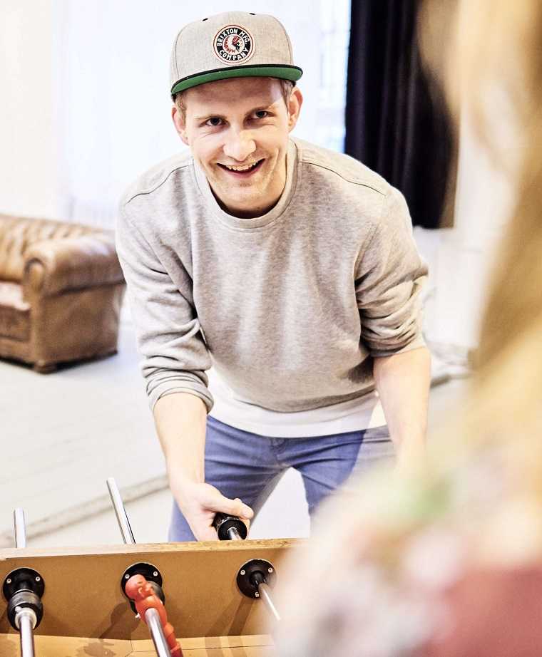Morbus Bechterew Patient Jonas spielt an einem Kickertisch