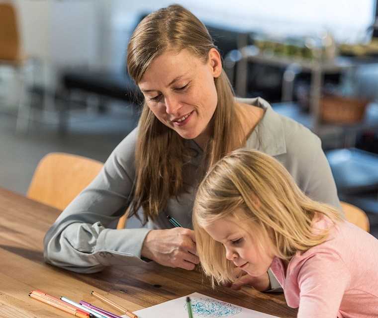 Morbus Bechterew Patientin Kathrin schaut ihrer Tochter beim malen zu Morbus Bechterew Patientin Kathrin schaut ihrer Tochter beim malen zu