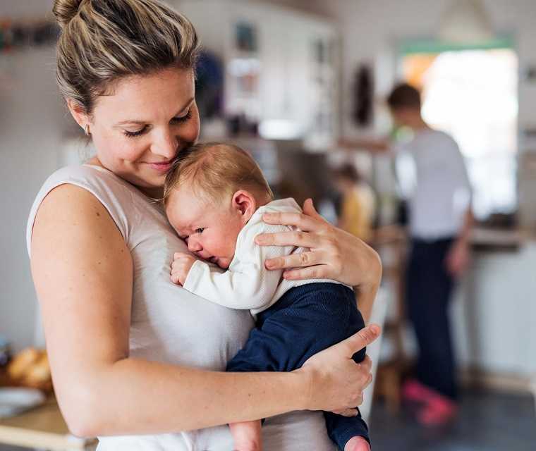 Mutter hält ihr Neugeborenes in den Armen