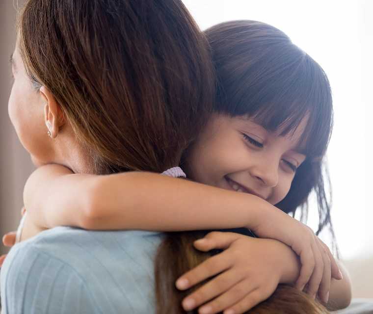 Mädchen umarmt glücklich ihre Mutter