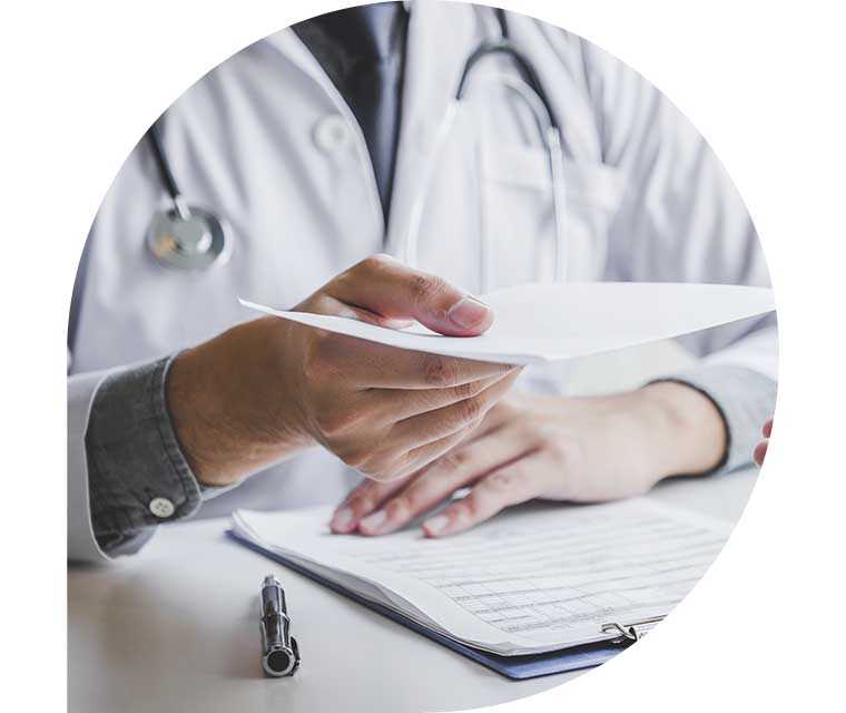 Eine Person im Arztkittel hält ein Blatt Papier in ihrer ausgestreckten Hand.