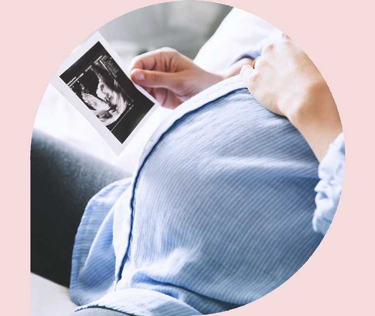 Eine schwangere Frau schaut sich das Ultraschallbild an