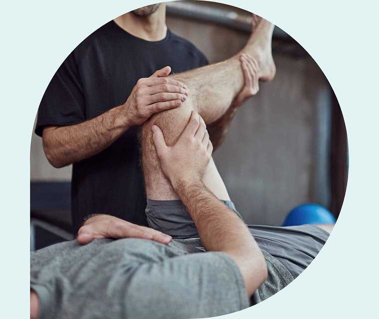 Ratgeber Rheuma: Physiotheraupeut macht Beinübungen mit einem Erkranken