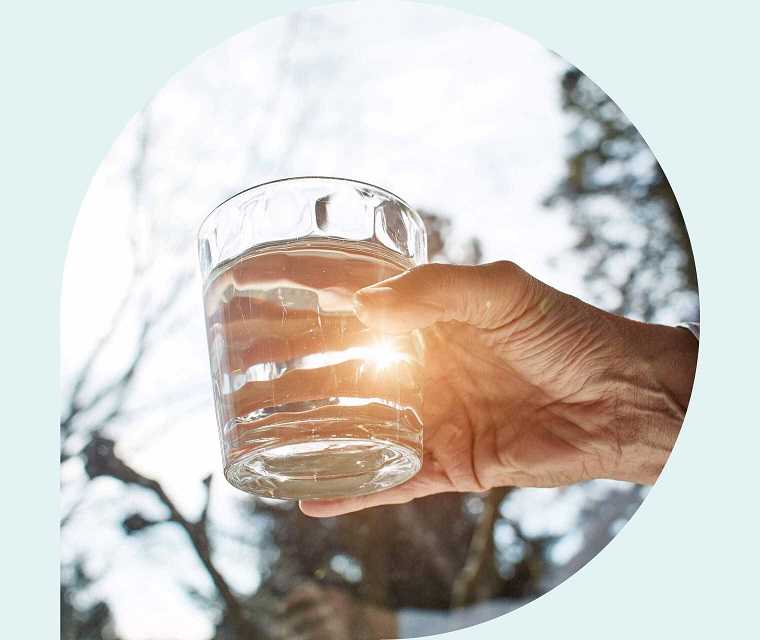 Ratgeber Rheuma: Eine ältere Hand hält ein mit Wasser gefülltes Glas Ratgeber Rheuma: Eine ältere Hand hält ein mit Wasser gefülltes Glas