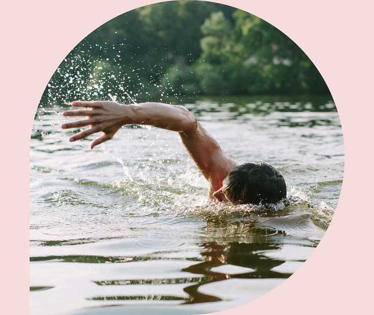 Ratgeber Rheuma: Ein Mann krault durch einen See Ratgeber Rheuma: Ein Mann krault durch einen See