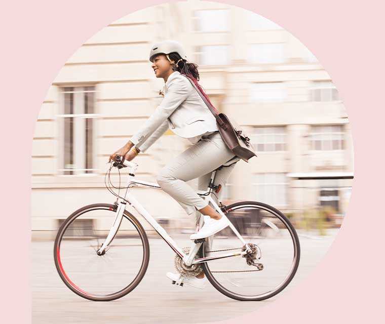 Ratgeber Rheuma: Eine junge Frau auf dem Fahrrad in der Stadt Ratgeber Rheuma: Eine junge Frau auf dem Fahrrad in der Stadt