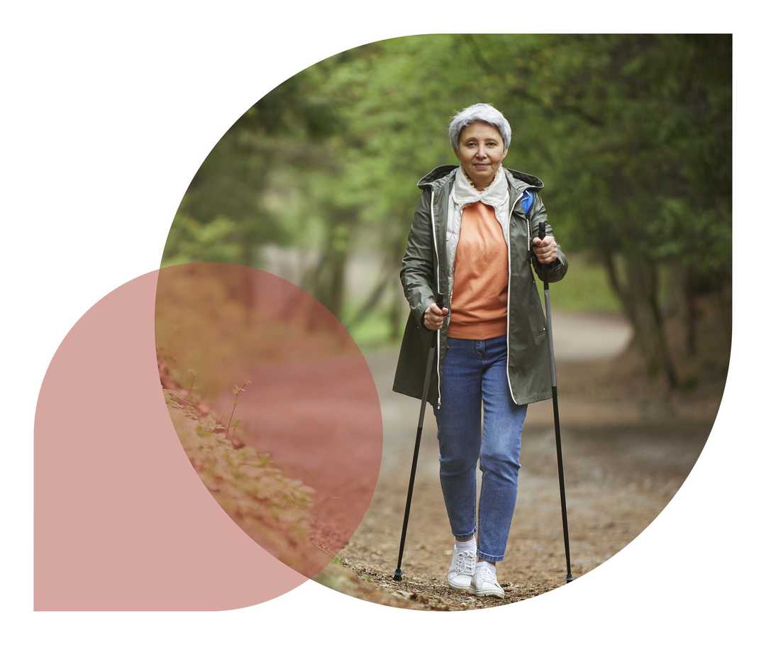 Ratgeber Rheuma: Ein Rheumatikerin beim Nordic Walking im Wald Ratgeber Rheuma: Ein Rheumatikerin beim Nordic Walking im Wald