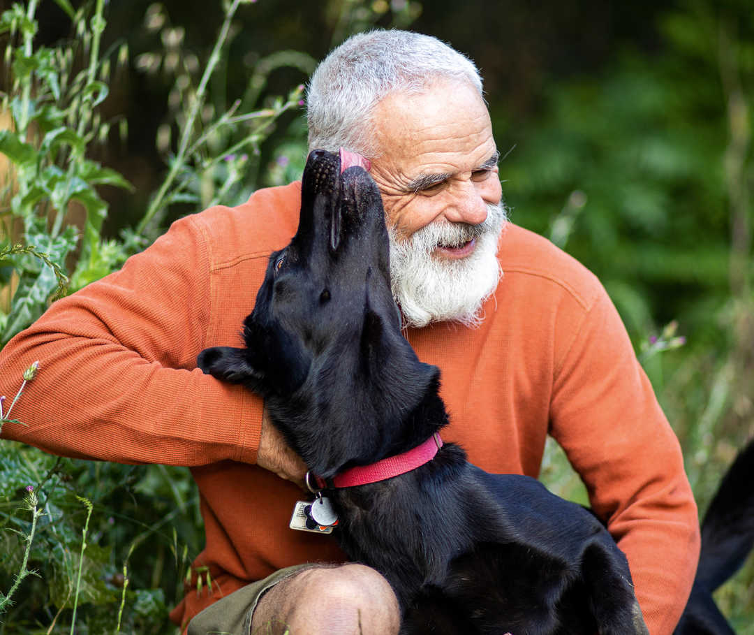 Ratgeber Rheuma: Ein älterer Mann liebkost seinen Hund Ratgeber Rheuma: Ein älterer Mann liebkost seinen Hund