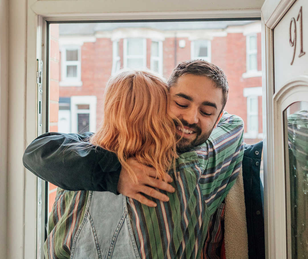 Junger Mann umarmt seine Freundin