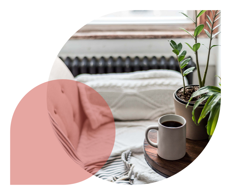 Ratgeber Rheuma: Eine Tasse Kaffe lädt zum Enspannen auf einem Sofa am Fenster ein