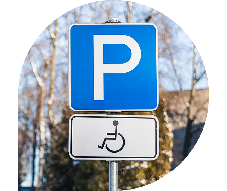 Ratgeber Rheuma: Ein Verkehrszeichen mit Rollstuhlsymbol weist auf einen Parkplatz für gehbehinderte Menschen hin