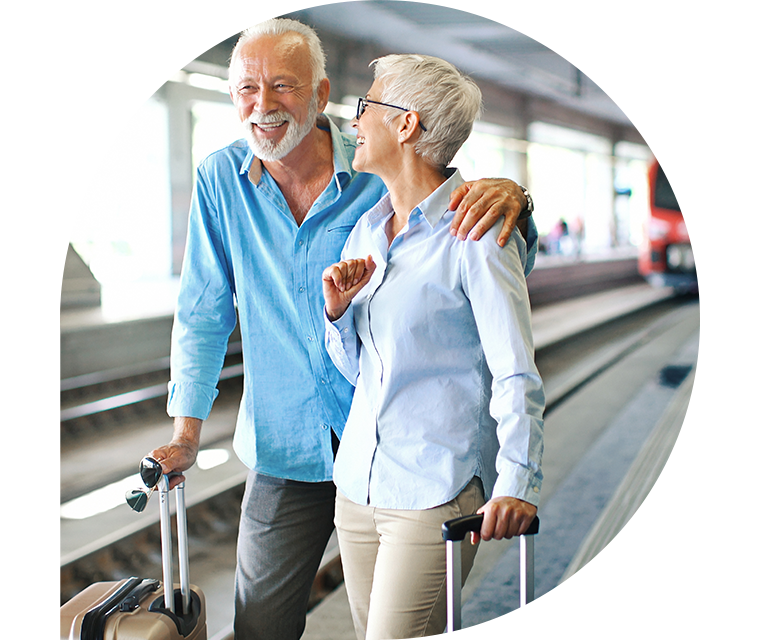 Ratgeber Rheuma: Ein älteres Paar steht am Bahnhof und freut sich auf seine Urlaubsreise