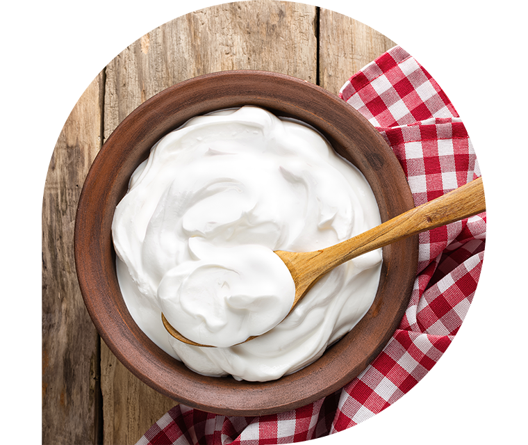 Eine Schale mit frischem Joghurt steht auf einem Holztisch