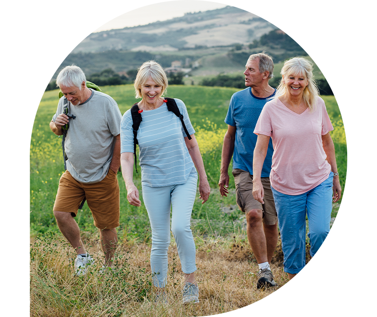 Eine Gruppe Wanderer auf einer Wiese in einer Hügellandschaft