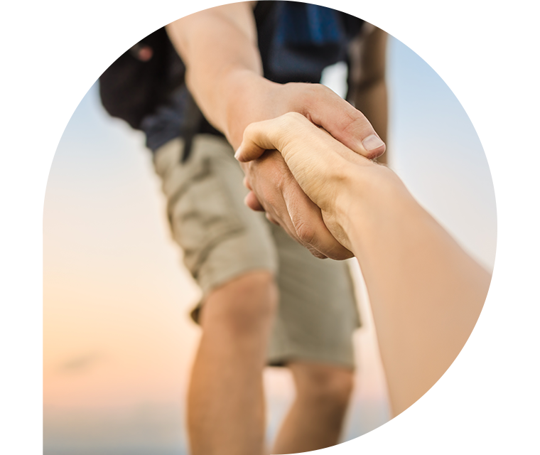 Ein Mann packt die Hand eines anderen und zieht ihn hoch