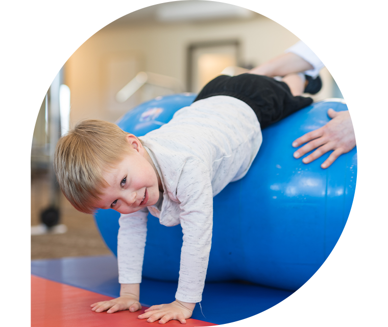 Ein Junge macht Übungen auf einem Gymnastikball