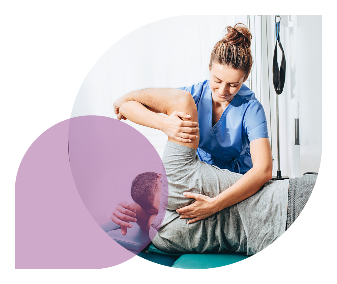 Eine Physiotherapeutin behandelt die Schulter eines Patienten