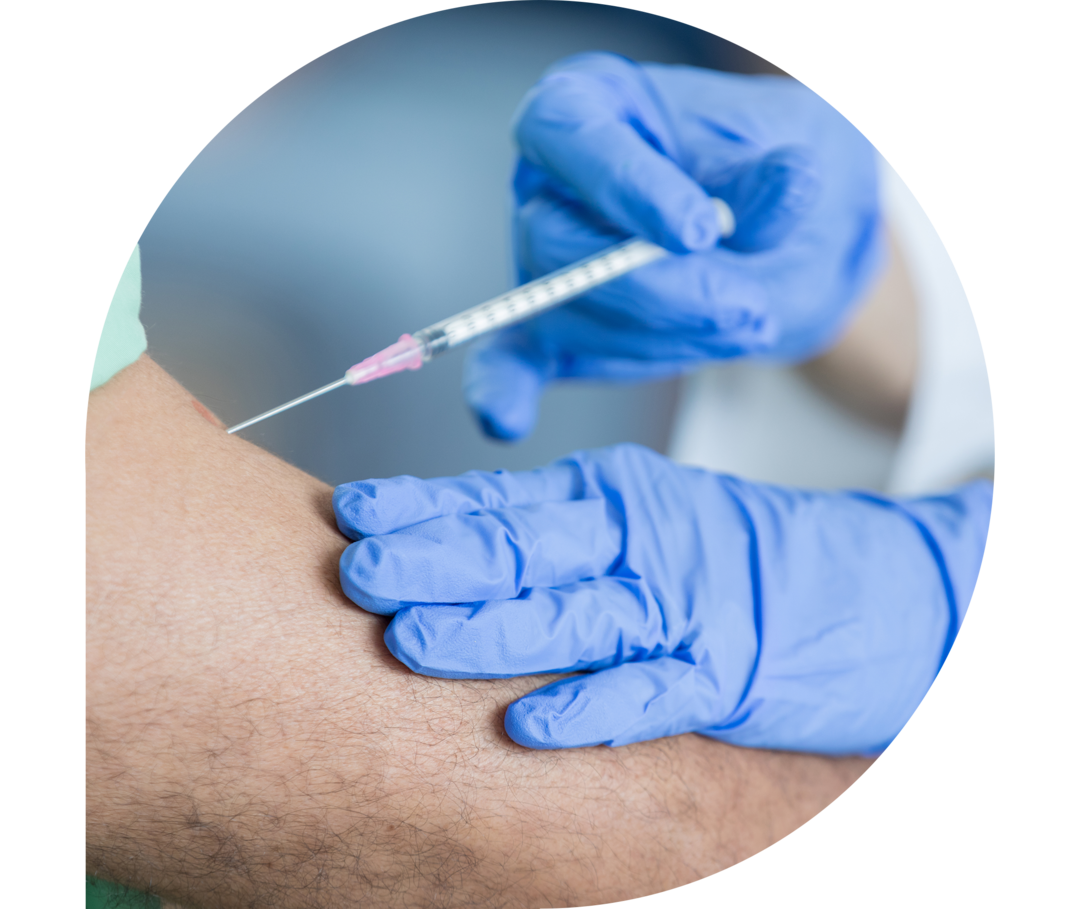Ein Arzt führt eine Spritze in den Oberarm eines Patienten Ein Arzt führt eine Spritze in den Oberarm eines Patienten