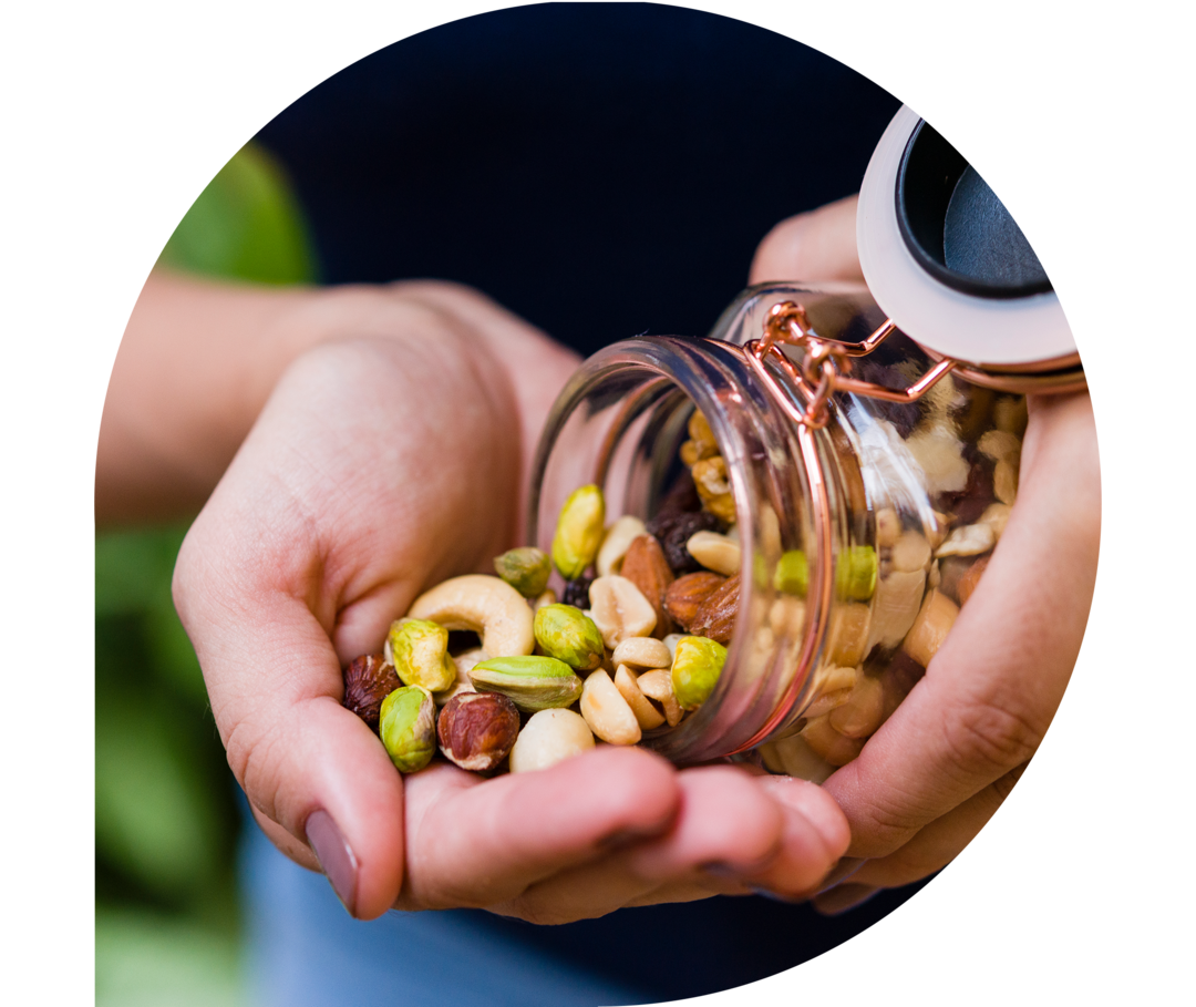 Ratgeber Rheuma: Eine Frau schüttet sich Nüsse aus einem Glas in ihre rechte Hand Ratgeber Rheuma: Eine Frau schüttet sich Nüsse aus einem Glas in ihre rechte Hand