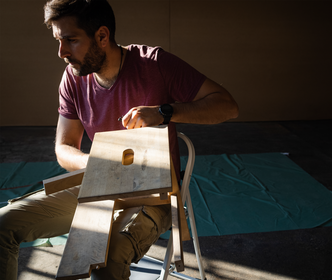 Ein Mann sitzt auf einer Leiter und erledigt handwerkliche Arbeiten