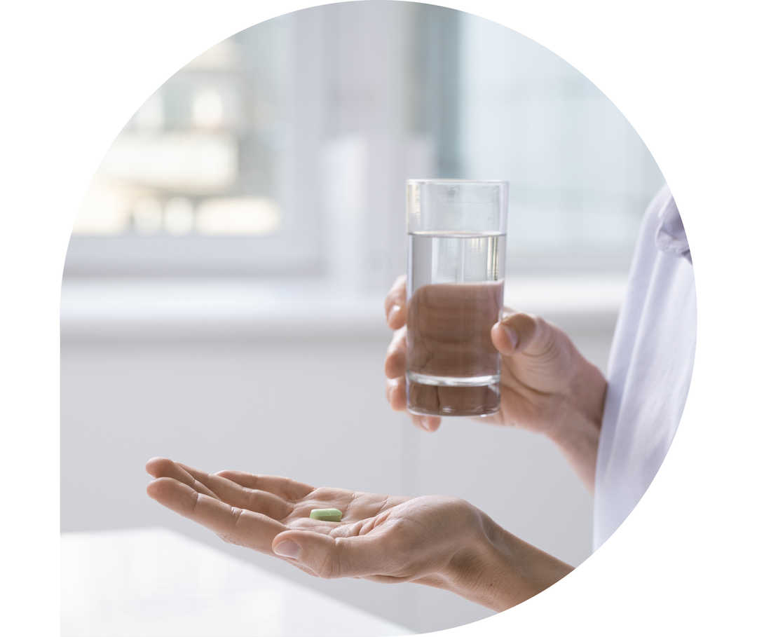 Ratgeber Rheuma: Eine Frau hält in der einen Hand eine Tablette, in der anderen hand ein Wasserglas