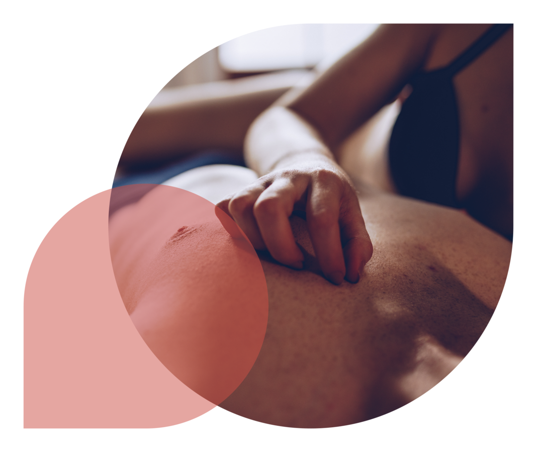 Ein Paar, dessen Gesichter nicht zu erkennen sind, liegt im Bett. Sie streichelt ihm zärtlich die Brust.