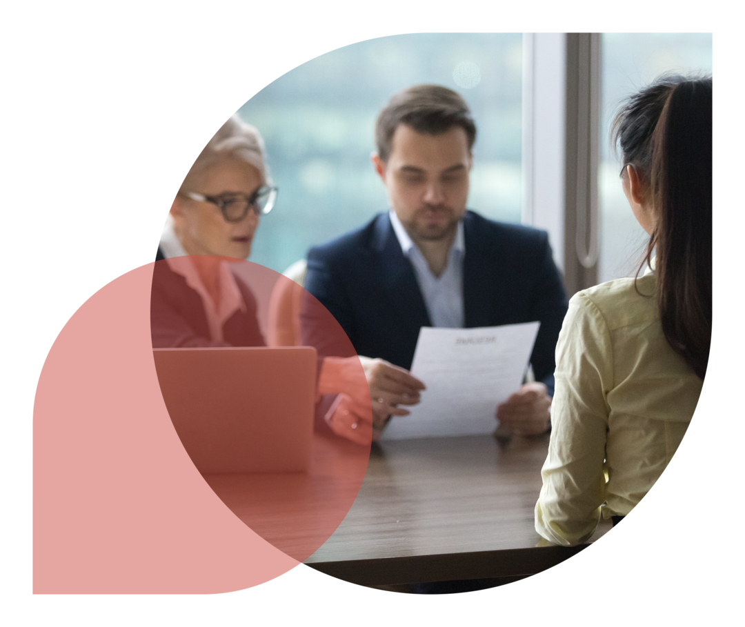 Eine junge Frau beim Bewerbungsgespräch mit einer Frau und einem Mann.