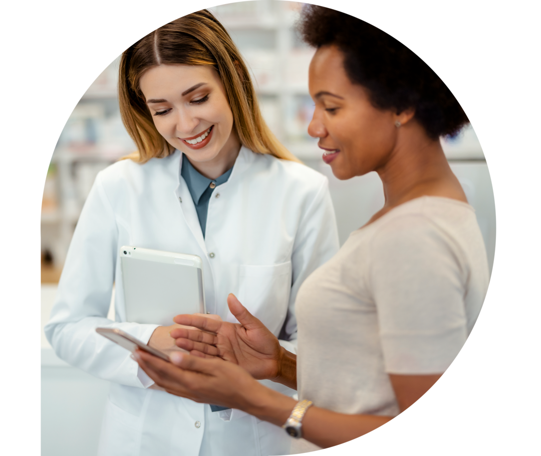 Eine junge Frau zeigt einer Apothekerin ihr Handydisplay