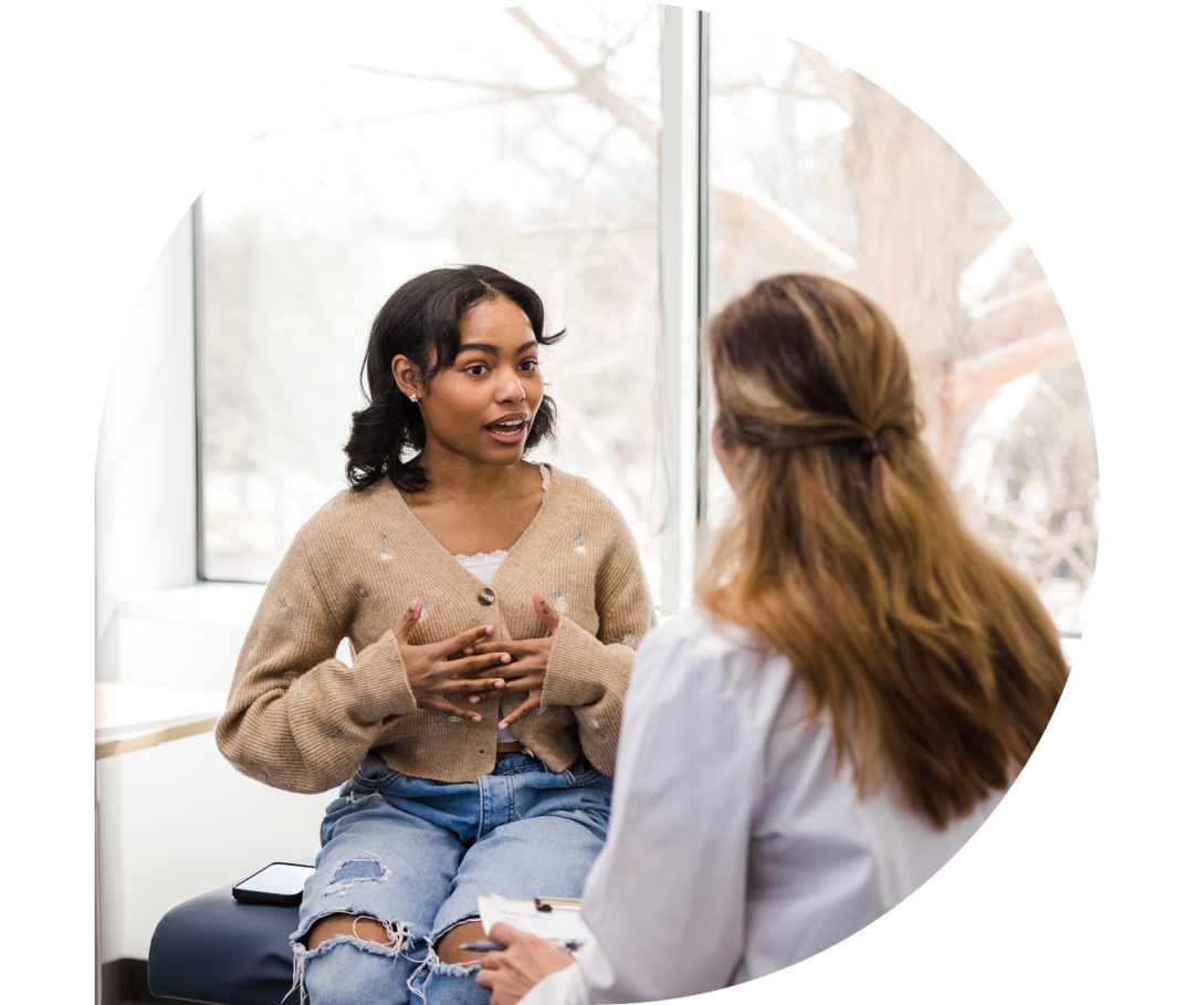 Eine junge Frau spricht mit einer Ärztin.