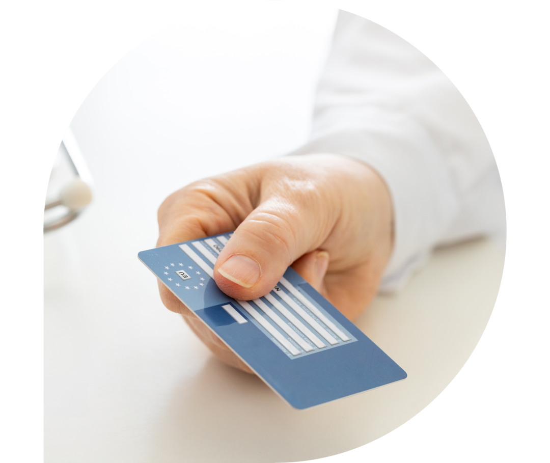 Das Bild zeigt zwei Hände: Die eine reicht der anderen Hand eine Gesundheitskarte.